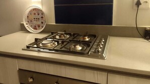 Une cuisine équipée d’une cuisinière à gaz, d’un four encastré et d’une prise de courant.