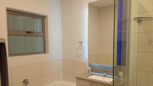 Une salle de bain moderne avec une baignoire, un lavabo et une douche à parois de verre.