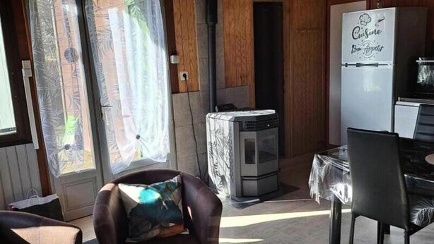 A cozy room with a sofa, a table, and a refrigerator. - G[?]aete de France 4 People (Antrenas)
