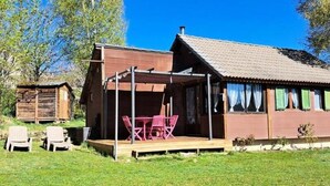 A wooden cabin with a porch, a table, and two chairs. - G[?]aete de France 4 People (Antrenas)