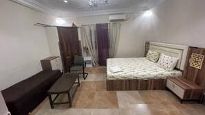 Ein Schlafzimmer mit Bett, Schreibtisch, Stuhl und Schlafsofa.