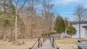A wooden staircase leading to a dock by a lake, surrounded by trees and a picnic table. - Canoe, Swim & Hike: Lakefront Brandenburg Home! (Brandenburg)