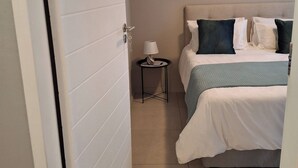 A bedroom with a bed, pillows, a small table with a lamp, and two horse paintings on the wall. - Oak & Olive Retreat Midrand (Midrand)