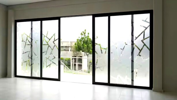 A spacious room with large floor-to-ceiling windows, a modern design, and a view of a building and trees outside. - Oak & Olive Retreat Midrand (Midrand)