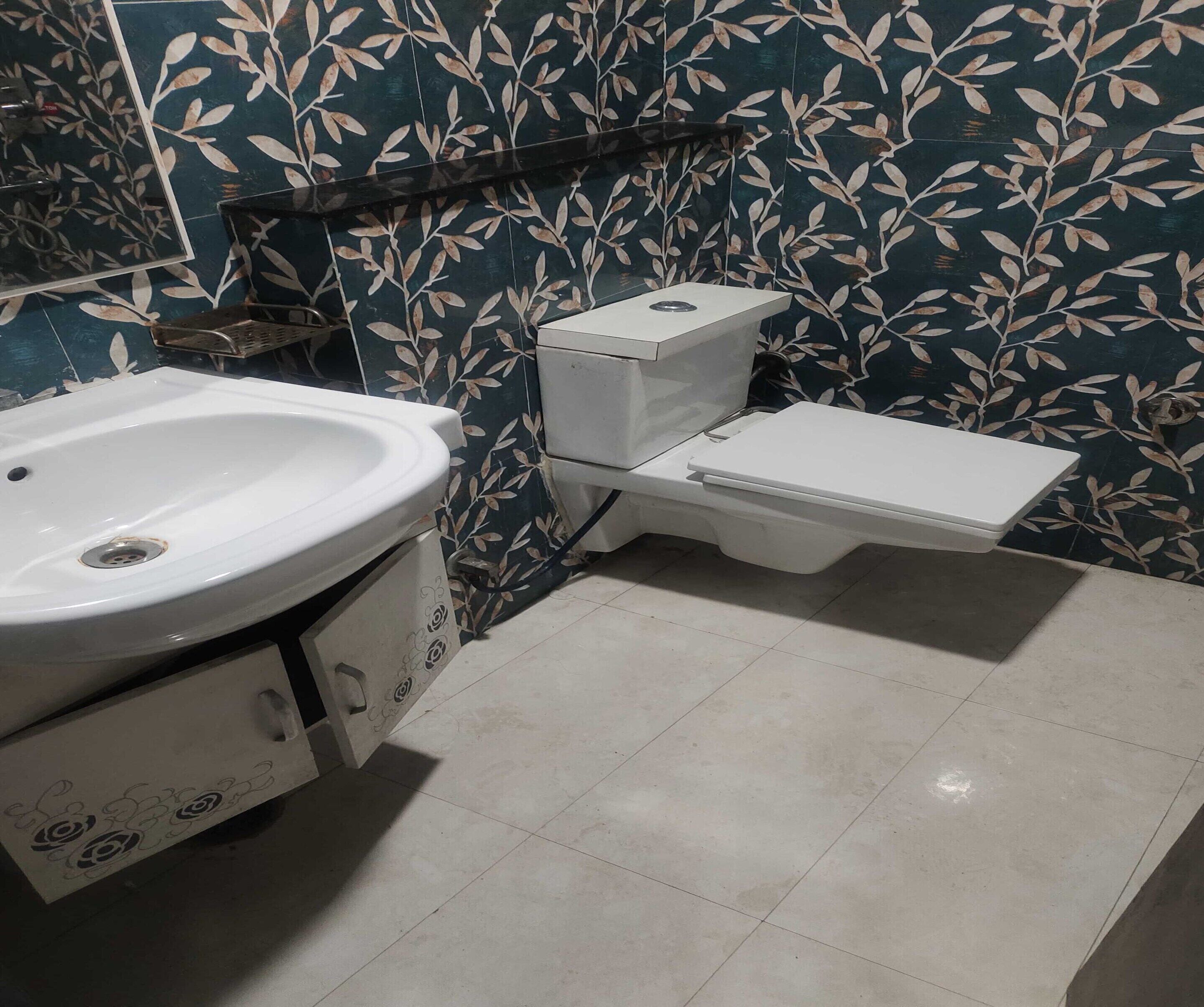 A bathroom with a white sink, toilet, and tiled floor.
