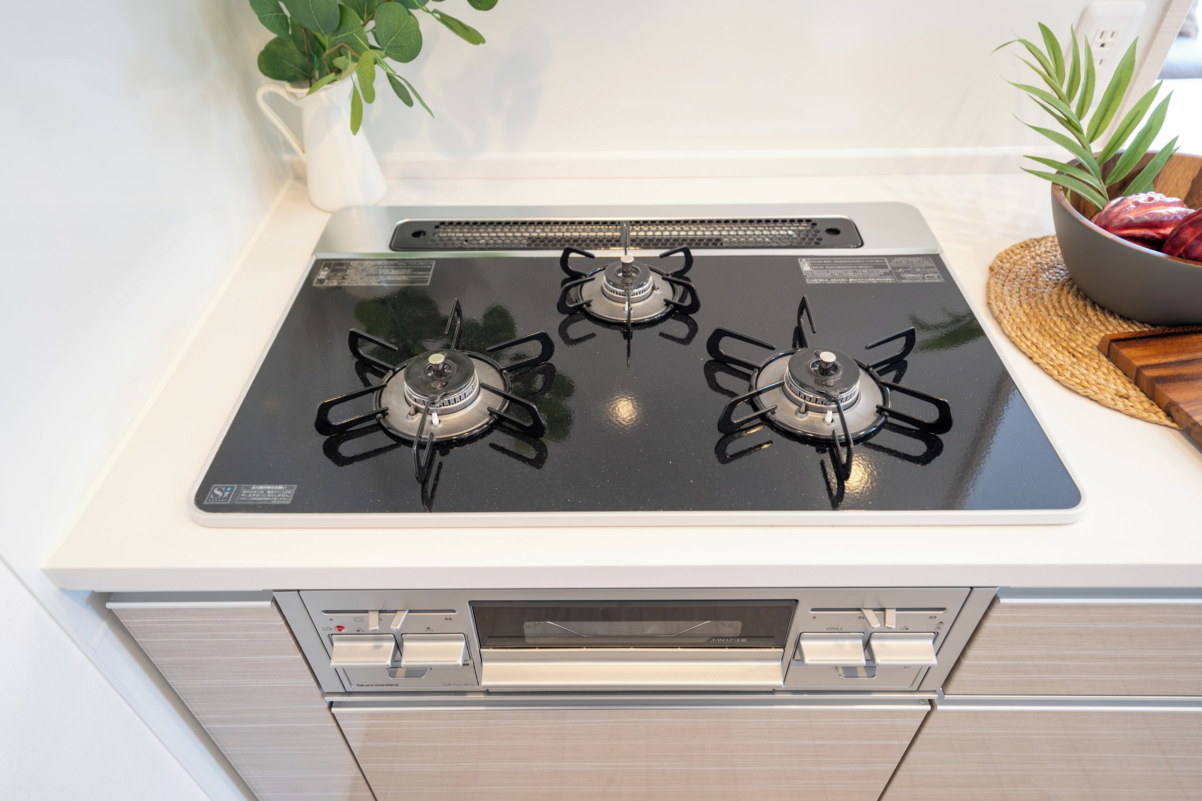 A kitchen with a gas stove, oven, and a white countertop.