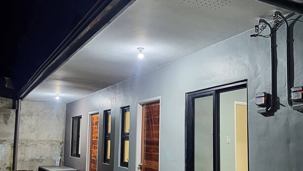 A building exterior with a concrete floor, three wooden doors, and a window. - NEWLY RENOVATED ROOMS NOW OPEN FOR INQUIRIES AND RESERVATIONS (Angeles Pampanga)