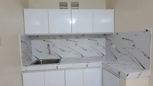 A compact kitchen with white cabinets, a marble backsplash, and a built-in sink. - NEWLY RENOVATED ROOMS NOW OPEN FOR INQUIRIES AND RESERVATIONS (Angeles Pampanga)