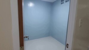 A small, unadorned room with a plain light blue wall, a white door, and a recessed ceiling light. - NEWLY RENOVATED ROOMS NOW OPEN FOR INQUIRIES AND RESERVATIONS (Angeles Pampanga)