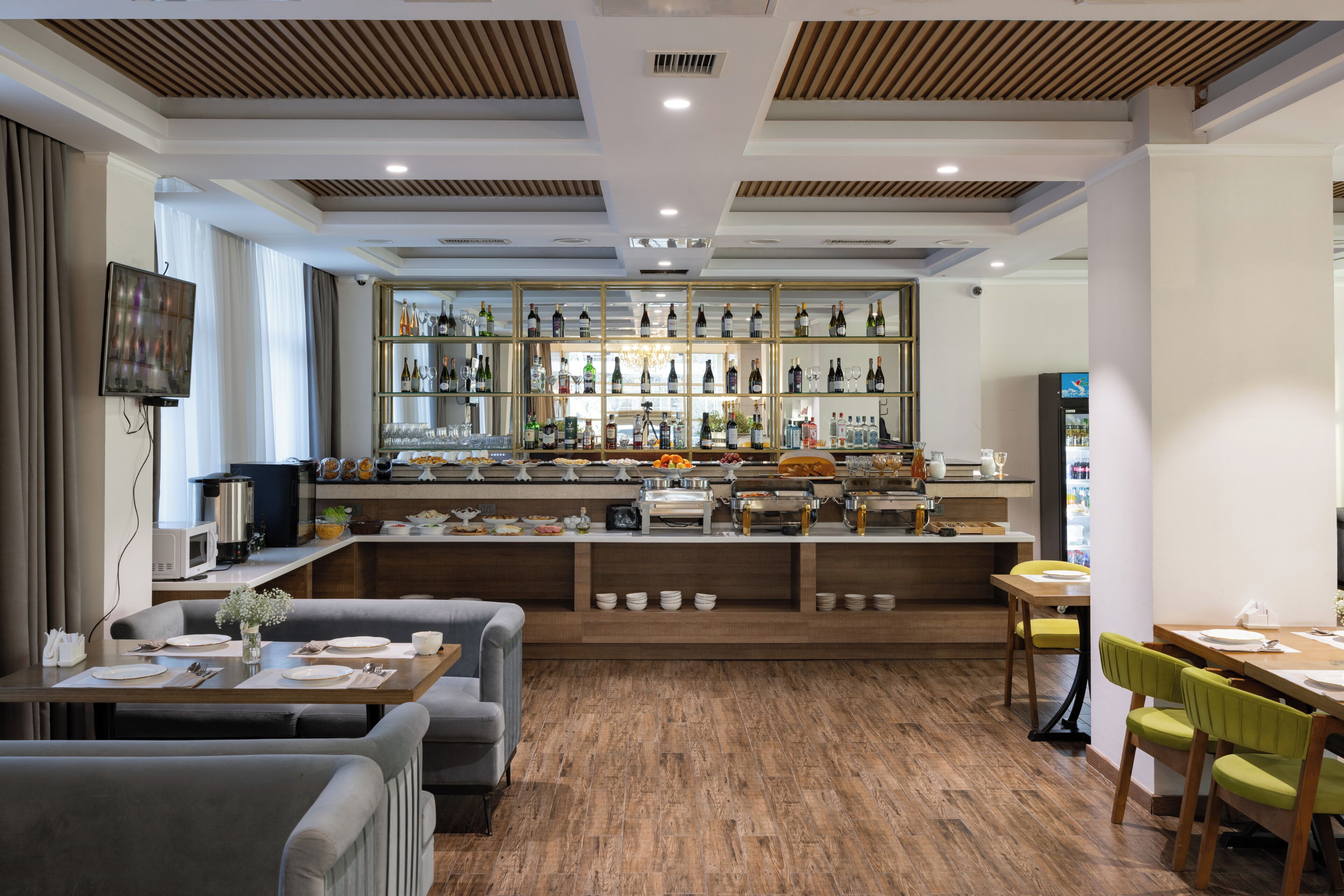 A modern bar area with a variety of beverages and a buffet setup.