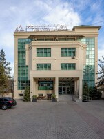 Un edificio moderno con un letrero que dice 'Mountain View Residence Hotel'. Presenta una fachada simétrica con ventanas amplias y una entrada central.