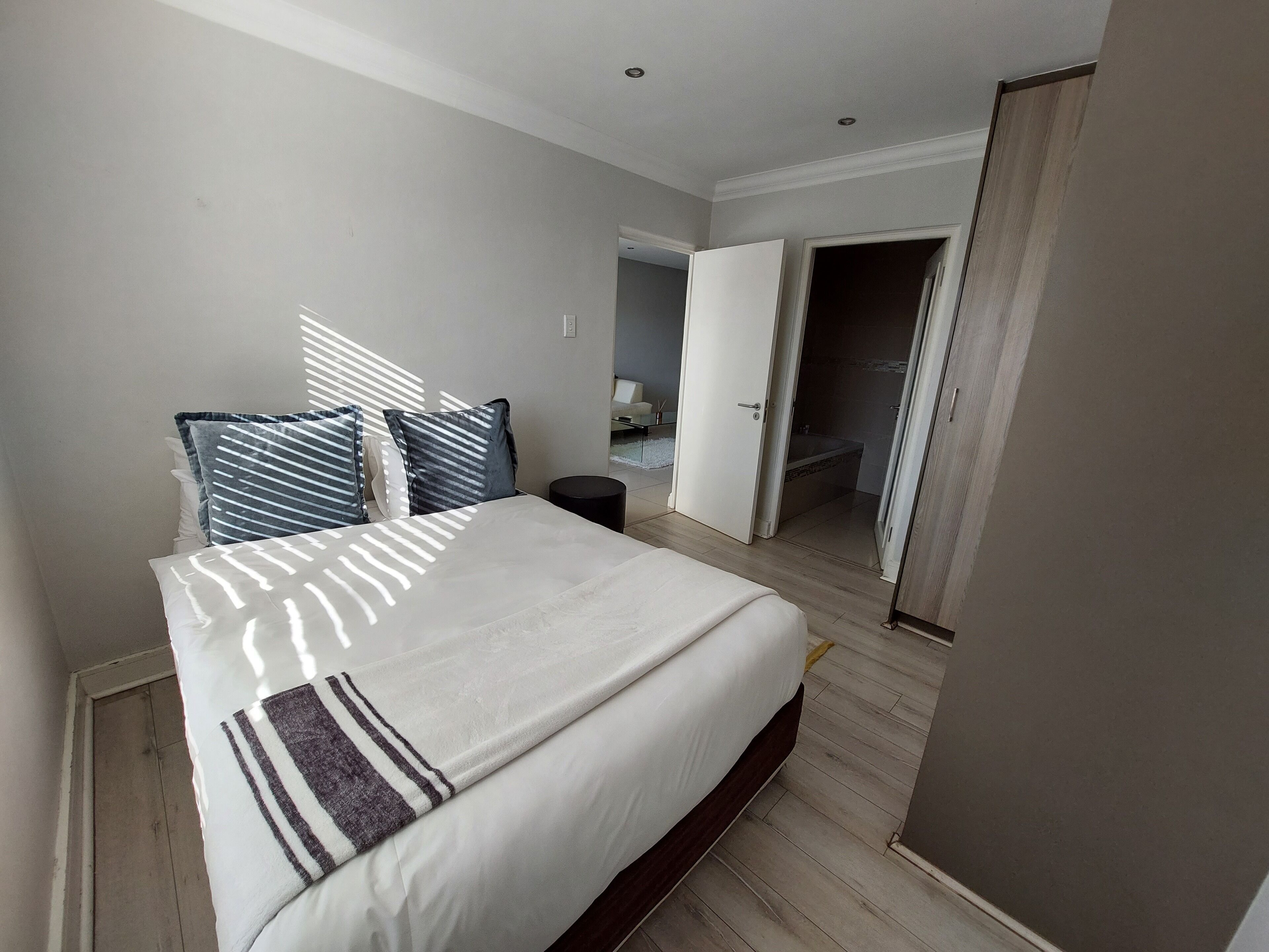 Une chambre à coucher avec un grand lit, une table de chevet et une armoire.