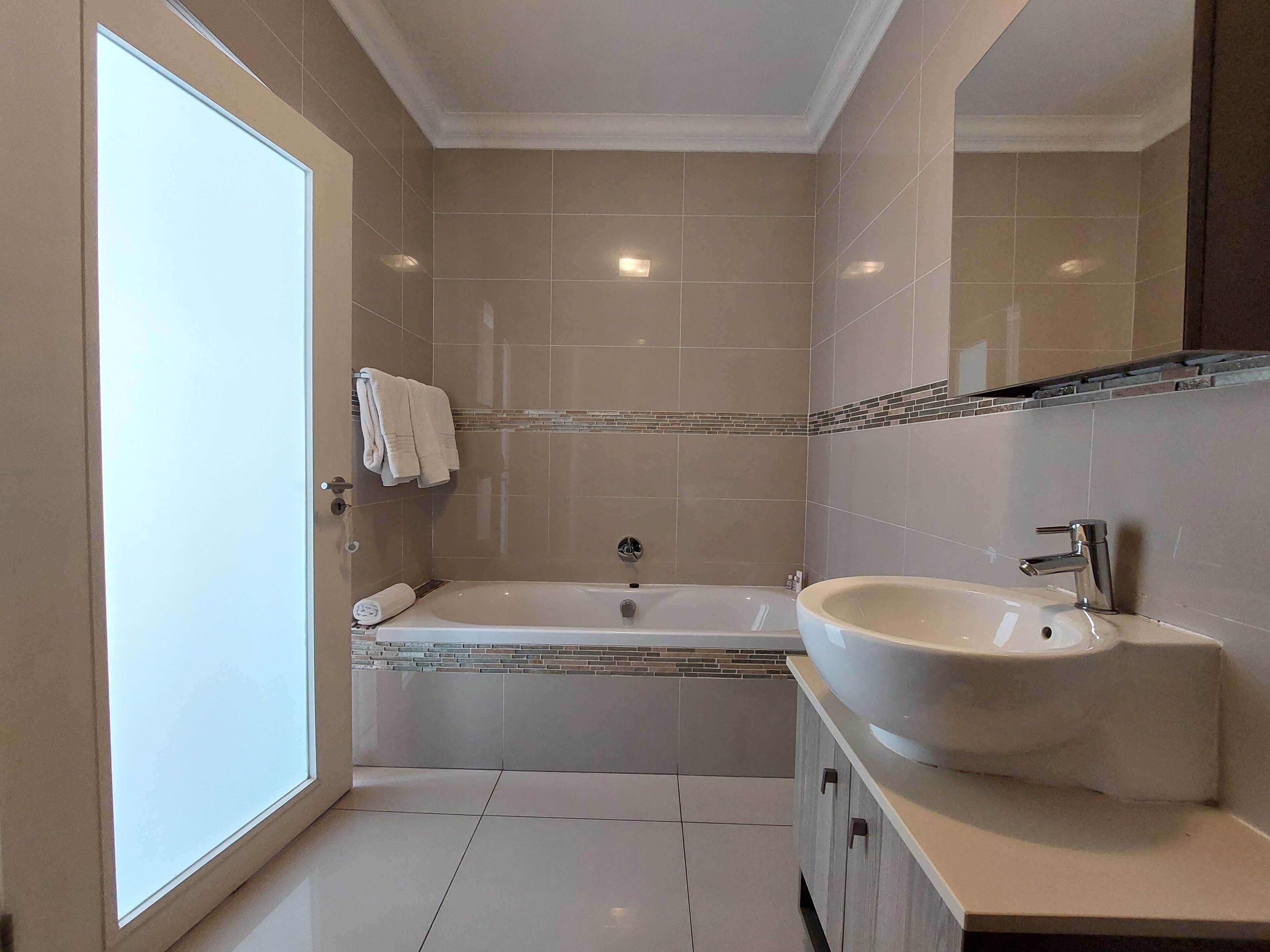 Ein modernes Badezimmer mit Badewanne, Waschbecken und Dusche.