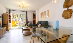 Ein modernes Wohnzimmer mit einem Glastisch, einer Couch und einer Chandelüster.