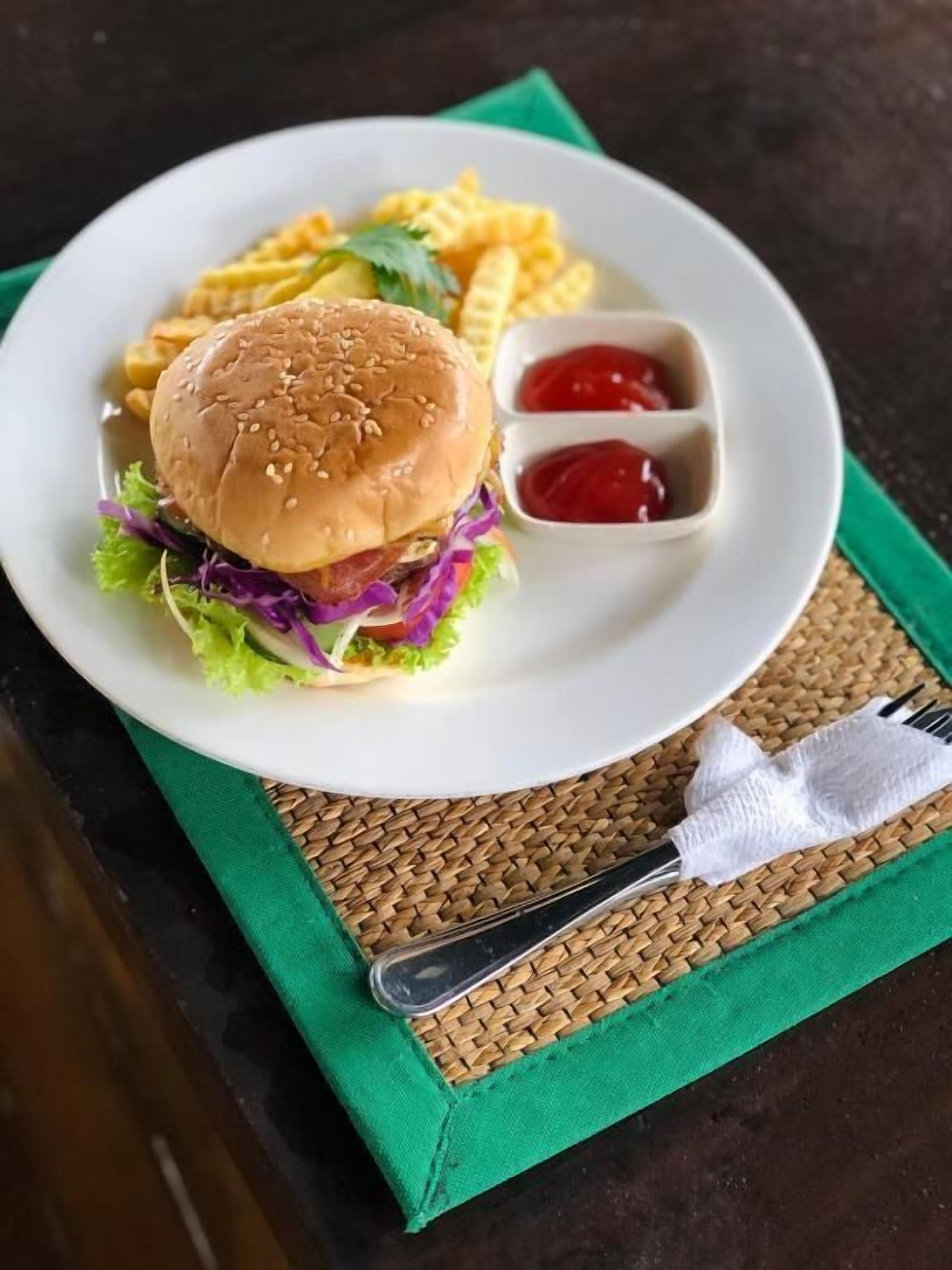 A plate with a burger, fries, and ketchup.