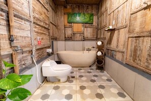 A bathroom with a wooden interior, a bathtub, a toilet, and a sink. - Room-deluxe Double or Twin Room (Ubud)