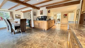 Un'ampia cucina con travi in legno, un'area pranzo con sedie e una grande isola.