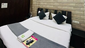 Habitación de hotel con cama, ventilador de techo, unidad de aire acondicionado y pared con textura.