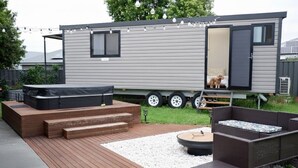 Une maison mobile moderne dotée d’une terrasse, d’un jacuzzi et d’un espace salon extérieur.