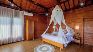 Quarto de madeira com uma cama sob um dossel, um tapete redondo e uma mesa de cabeceira com uma planta.