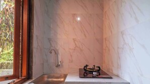 A kitchen with a marble backsplash, a stainless steel sink, and a gas stove. - One Bedroom Villa With Swimming Pool (Tegallalang)