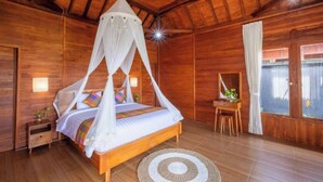 A wooden room with a bed, a small table, and a window. - One Bedroom Villa With Swimming Pool (Tegallalang)