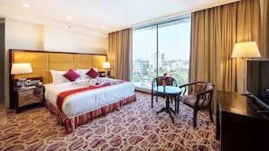 Une chambre d’hôtel avec un grand lit, un bureau, une chaise et un téléviseur.