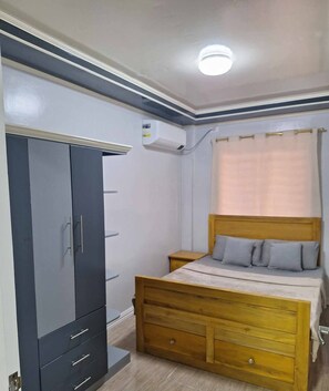 Ein Schlafzimmer mit einem Bett, einem Kleiderschrank und einer Klimaanlage.