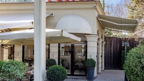 A building with a cafe sign, outdoor seating, and a paved entrance area. - Mountain View Boutique Almaty (Almaty)