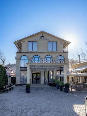 A hotel with a prominent entrance, a covered outdoor seating area, and a clear view of the surrounding buildings. - Mountain View Boutique Almaty (Almaty)