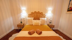A hotel room with a large bed, two bedside tables, a headboard, and two wall-mounted lamps. - THE CHARM OF LES BERCEAUX: 5 minutes from Avenue de Champagne and right in the heart of the city (Épernay)