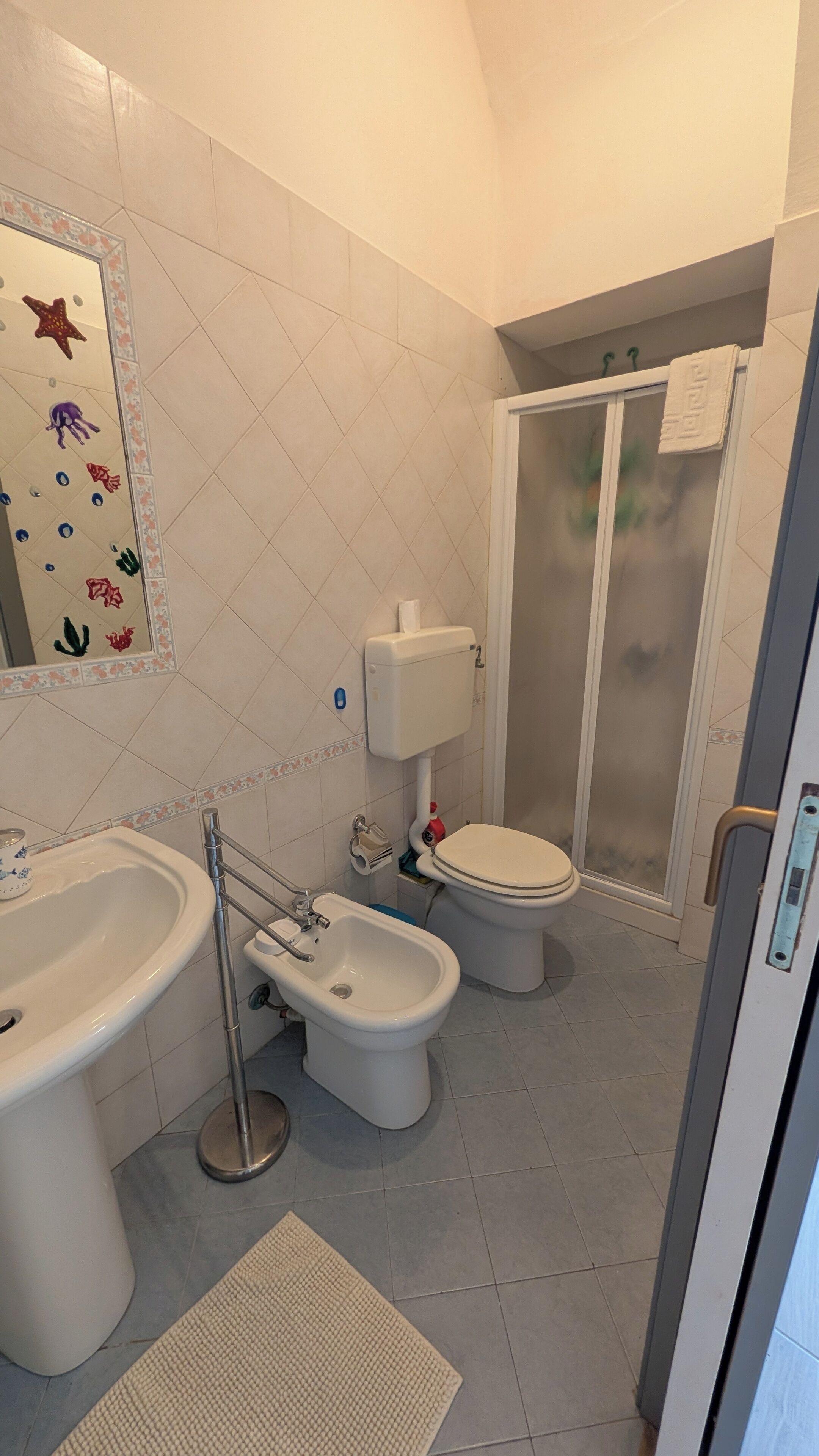 Un baño con inodoro, bidé, lavamanos y zona de ducha.