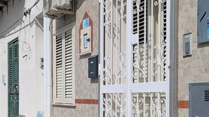 Un edifici amb una gran porta blanca, número 18, i una petita casseta de correu a la paret.