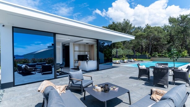 Un espacio moderno al aire libre con piscina, asientos y vistas al paisaje.