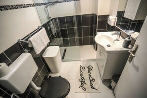 Une salle de bain moderne équipée de toilettes, d’un lavabo et d’une douche.