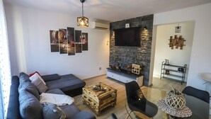 Een moderne woonkamer met een bank, salontafel en tv-bevestiging aan de muur.