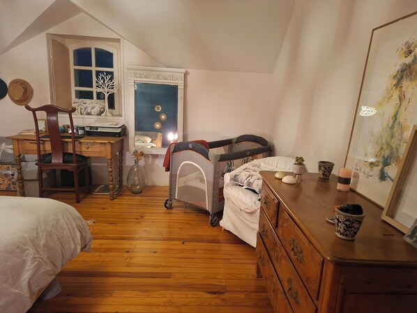 A cozy bedroom with a wooden floor, a desk, a chair, a bed, a crib, and a dresser. - AU 15 : charming house with garden, 3 bedrooms 3 bathrooms 6 km from the beach, animals ok (Quettreville-sur-Sienne)