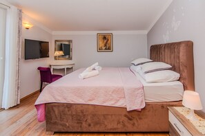 A bedroom with a bed, a desk, a chair, a TV, and a painting on the wall. - Charming Holiday Home in Maslenica (Jasenice)