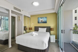 A hotel room with a large bed, two bedside lamps, a painting on the wall, and a balcony with a railing. - Brisbane City Retreat with Private Balcony (Brisbane City)