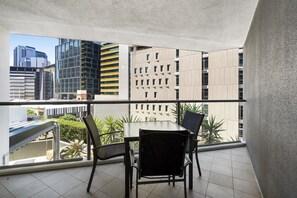 A balcony with a table and chairs, offering a view of modern buildings and a cityscape. - Brisbane City Retreat with Private Balcony (Brisbane City)