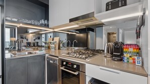 Uma cozinha moderna com eletrodomésticos de aço inoxidável, forno embutido e cafeteira.