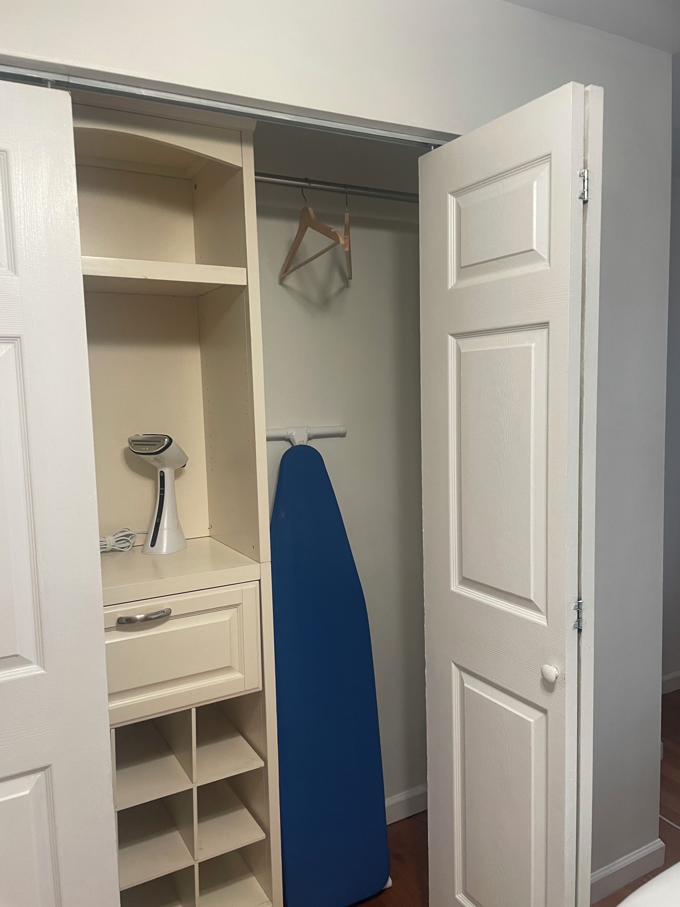 A closet with shelves, a hanging rack, and a door.