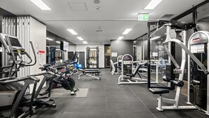A modern gym with various exercise equipment, including treadmills, weight machines, and free weights.
