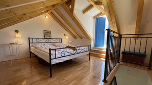 A bedroom with a bed, a small table, and a chair. There is a window with blue shutters and a door. - Holiday Home Cherry With Pool (Marina)