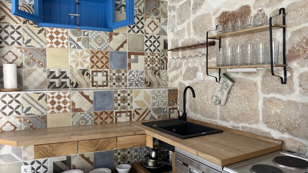 A kitchen with a built-in dishwasher, a stove, and a blue cabinet. - Holiday Home Cherry With Pool (Marina)
