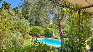 Ein Pool, umgeben von üppiger Vegetation und einem weißen Stuhl.
