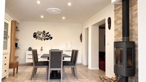 Ein Essbereich mit Tisch und Stühlen, einem Kamin und einer Wand mit Dekoration.