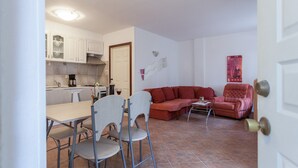 Ett kompakt bostadsutrymme med en matplats, en soffa och ett kök.