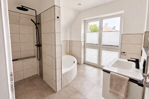 Ein modernes Badezimmer mit Dusche, Badewanne und Waschbecken.