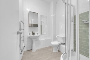 Ein modernes Badezimmer mit Duschkabine aus Glas, einem Standwaschbecken und einer Toilette.